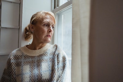 mature woman looking out of the window 
